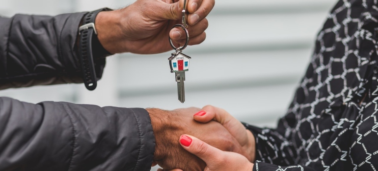 The man hands the woman the keys to the house after studied real estate prices in Tennessee in 2022 .