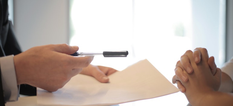 a man holding a pen and a contract