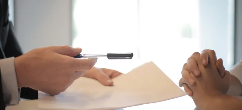 a man holding a pen and a contract