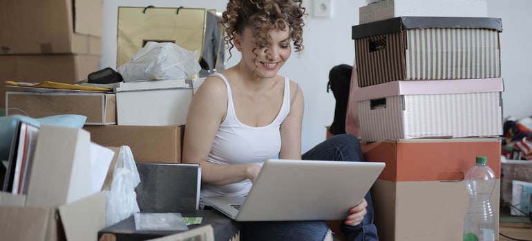 Mujer que usa el ordenador portátil a la investigación en movimiento desde los suburbios de la gran ciudad