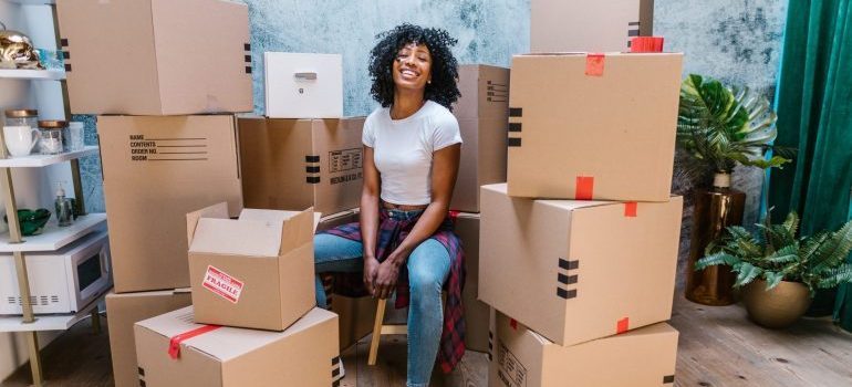 una mujer rodeada de cajas sonriendo