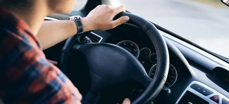 Un hombre que sostiene el volante y conducir 