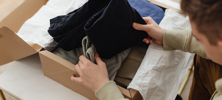 a man packing clothes on his own in order to lower the cost of an interstate move