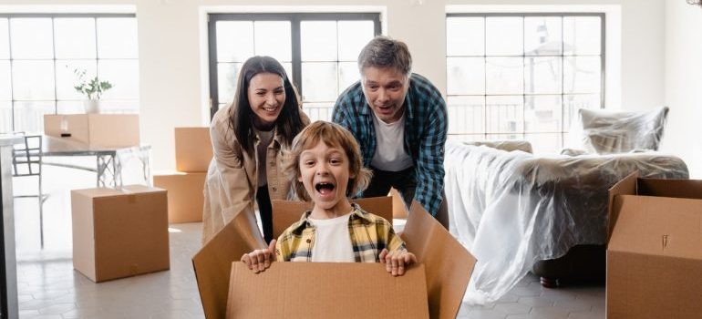 los padres que empujan a su niño que está en la caja