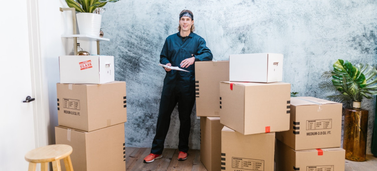 a professional mover standing next to boxes ready to tell you about benefits of moving to Memphis