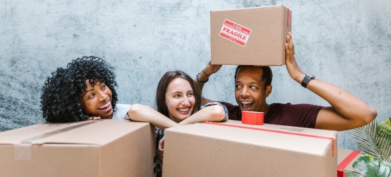 la gente sonriendo detrás de las cajas