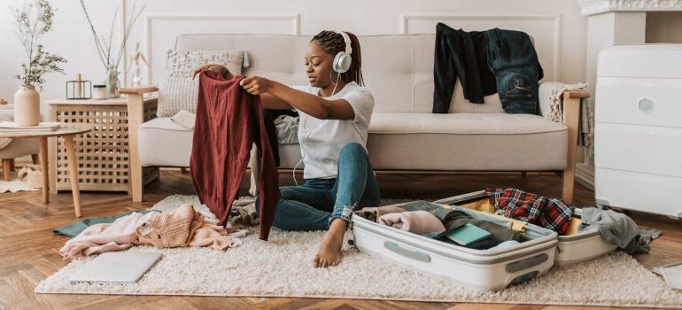 A woman sorting out clothes before packing