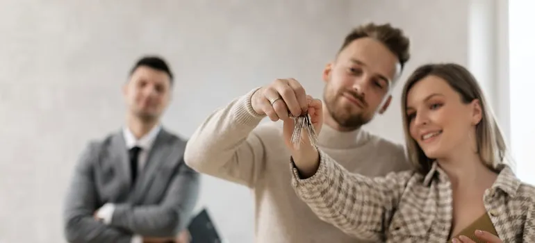 Pareja en la celebración de su llave de la casa después de mudarse a la ciudad de Baltimore