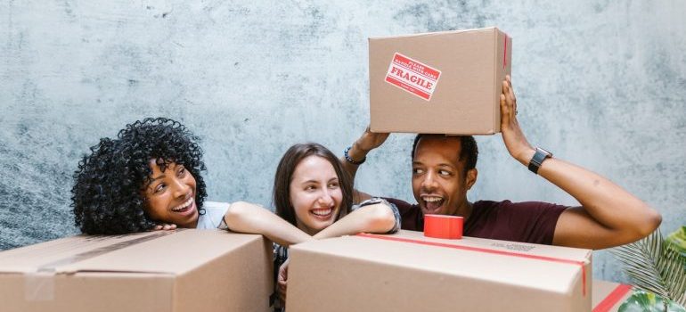 Amigos detrás de las cajas de averiguar cómo hacer la mudanza de estado de fácil