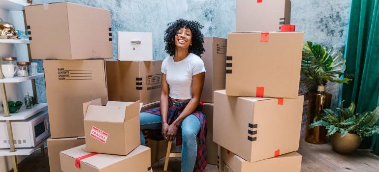 mujer rodeada de cajas sonriendo