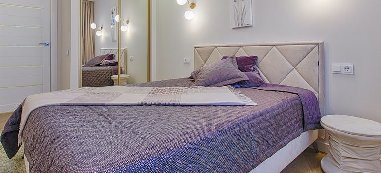 Un dormitorio con una pruple cama dentro