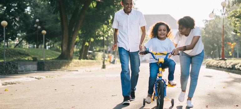 Los padres de aprendizaje de un niño a andar en bicicleta en uno de los mejores vecindarios de San Antonio para las familias