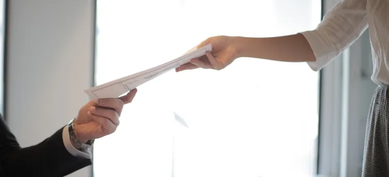 una persona que entrega los documentos a la otra persona
