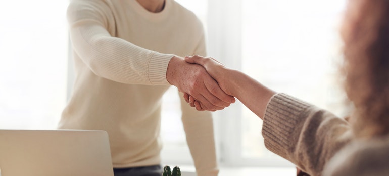 Un hombre y una mujer, un apretón de manos a través de la mesa