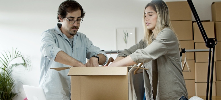 A woman and a man packing moving boxes before relocating from Texas to Ohio
