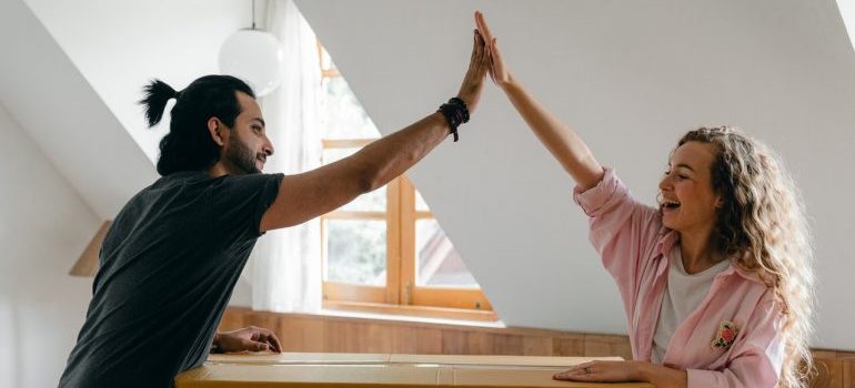 Couple doing a high five and thinking about the things to know before moving to Ohio