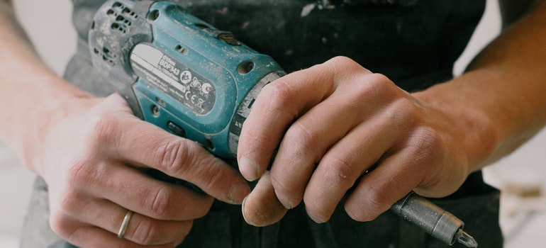 a person holding a drill ready to prepare your San Antonio home for sale