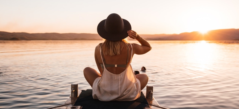 Una mujer sentada por el lago