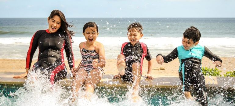 Mujer con niños en la playa haciendo una de las actividades divertidas para la familia después de mudarse a Miami 
