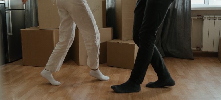 two pairs of legs dancing with cardboard boxes in the background