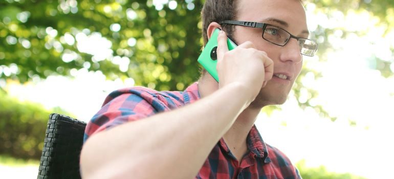 un hombre hablando por teléfono con cross country empresas de mudanzas de Austin ofrece 