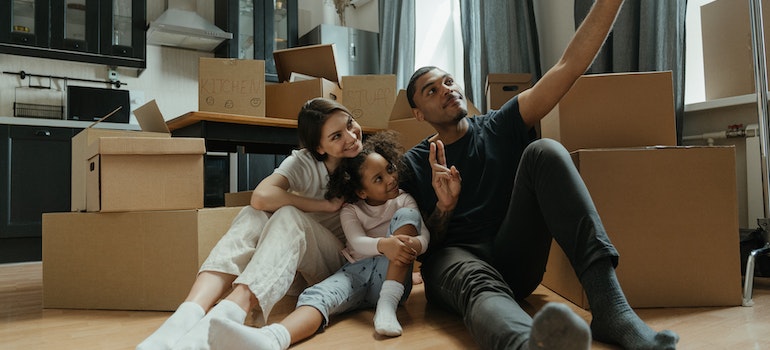 Una familia de tomar una selfie cerca de cajas de mudanza antes de mudarse a Miami en 2022