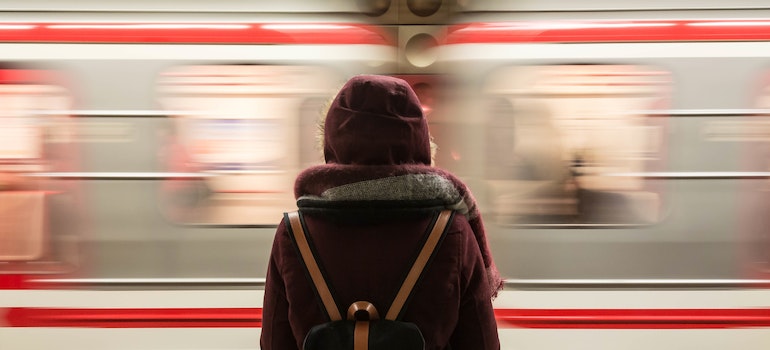 A woman facing the train which is in motion thinking about fun facts about Chicago you should know