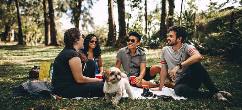 Four people and a dog in a park talking about pet friendly places in Texas