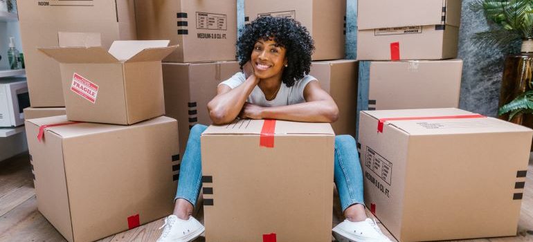 mujer rodeada de cajas de mudanza