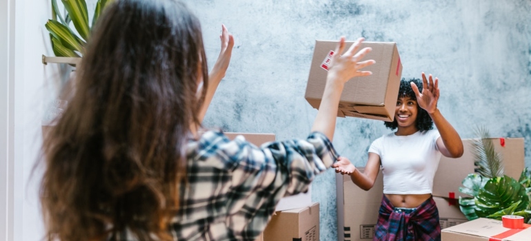 two girls tossing a box