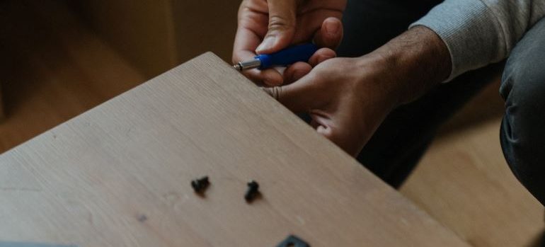 un hombre tratando de armar una tabla