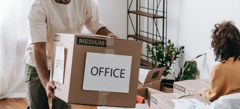 Man carrying large box to make your office move to the Woodlands enjoyable 