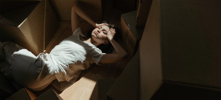 a girl laying down between the boxes before moving to one of the most affordable Florida places