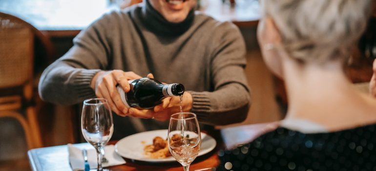 Hombre verter el vino en un restaurante de calidad 