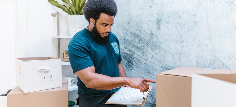 mover reviewing packed moving boxes