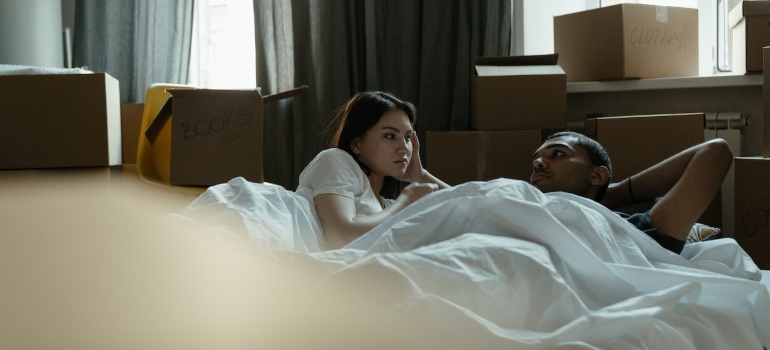 a couple laying in an improvised bed while being surrounded by cardboard boxes the first month after moving to Pearland