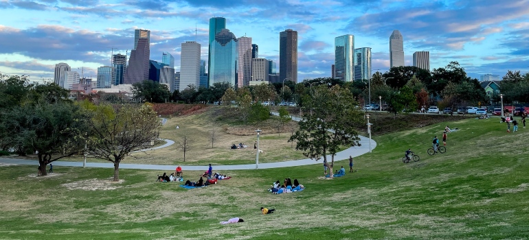 la gente se relaja en el suelo con los edificios en la distancia