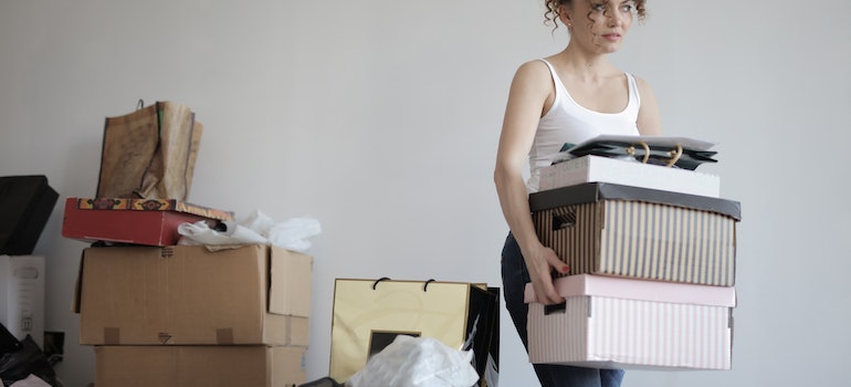 Mujer cargando cajas, la preparación para el movimiento por el plano