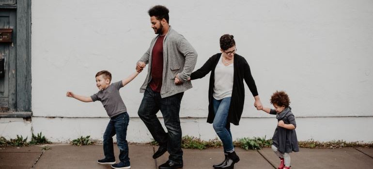 family walking down the road while holding hands 