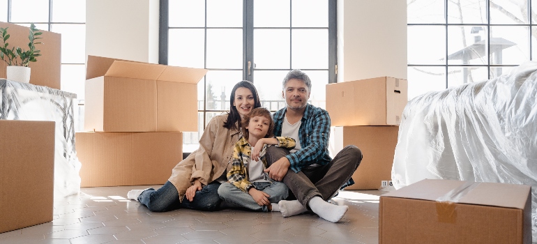family sitting on front of the moving boxes 