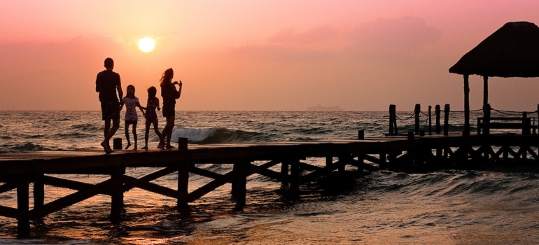 Las personas con niños en el muelle a disfrutar de la vida en la Isla Larga como padres.