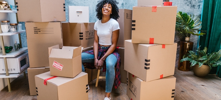 woman sitting next to the moving boxes before moving to La Grange TX