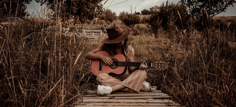 Una mujer tocando la guitarra después de mudarse de carolina del norte, Texas