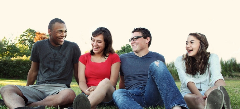 La gente sonriente sentado en la hierba y hablar acerca de los rasgos de Texas en el estilo de vida