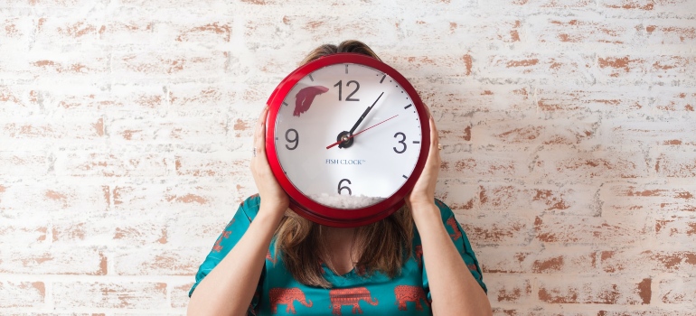 a woman holding a clock can tell you how to get ready for your Texas relocation