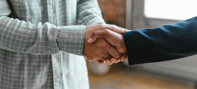 Two people shaking hands can tell you if you should buy a home in Dallas right now