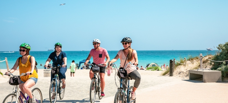 friends riding bikes on the beach