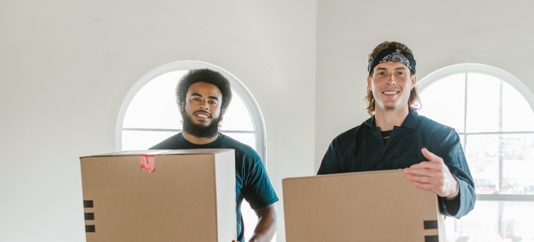 two movers holding boxes