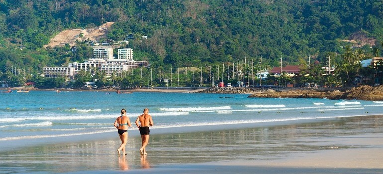 elderly couple jogging on a beach and thinking about the states you should retire in