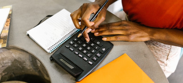 A person calculating costs to get ready for moving to Katy TX